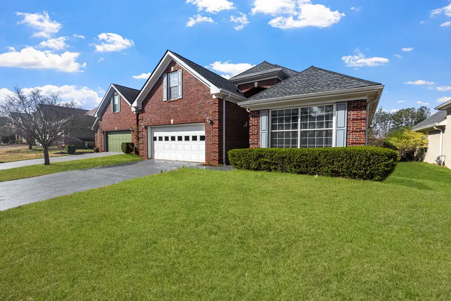 Single story brick home with a front lawn