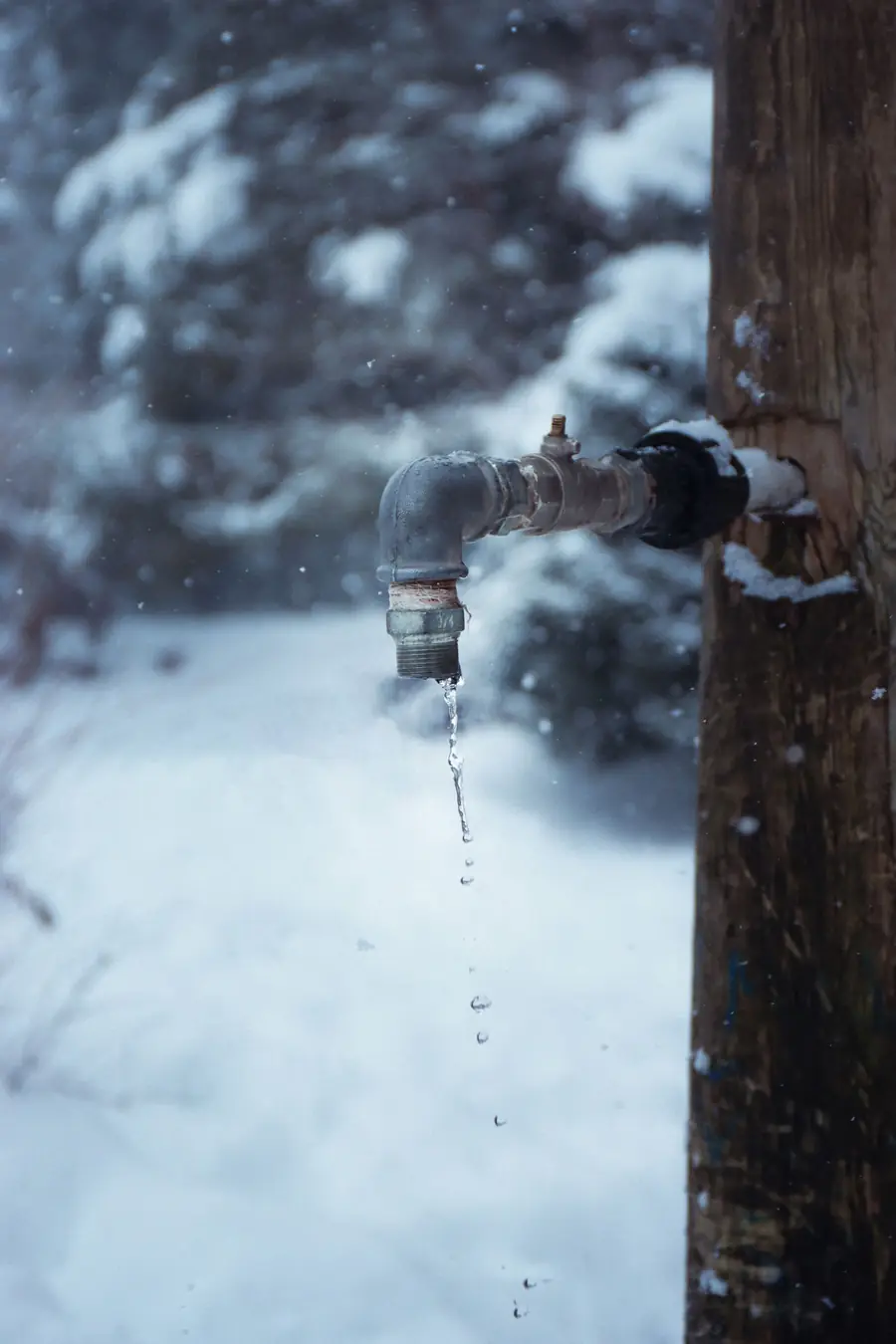Outdoor water spigot coated in ice during a hard freeze